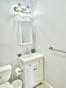 a bathroom with a sink and a toilet and a mirror at 204-Bright 2Bed 2Ba w Stainless Steel Appliances in Hoboken