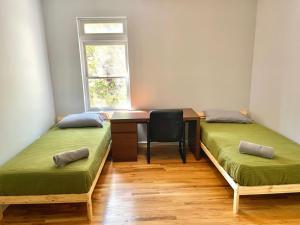 a room with two beds and a desk and a window at 204-Bright 2Bed 2Ba w Stainless Steel Appliances in Hoboken