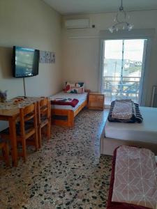 a room with two beds and a table and a television at Santi house in Souvala