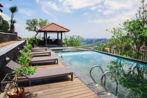 a swimming pool with benches and a gazebo at Dago Highland Resort in Bandung