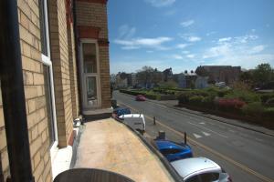 a balcony of a building with cars parked on a street at Park View Guest House in Bridlington