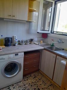 una cucina con lavatrice e lavandino di Santi house a Souvala