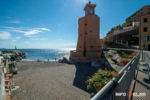 a clock tower on the beach next to the ocean at Appartamento e Mansarda al mare in Rio Marina