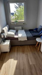 a bedroom with a bed and a window at Apartament Morski nr 4 Baltic Nova in Władysławowo