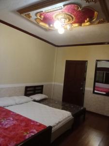 a bedroom with a bed and a ceiling with a painting at Villa Ceferina in Tagbilaran City
