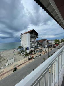 een balkon met uitzicht op een strand en een gebouw bij Nepheli in Paralia Katerinis