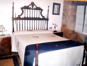 sypialnia z łóżkiem z drewnianym zagłówkiem w obiekcie 4 bedrooms house with garden and wifi at Lugo Galicia w mieście Argozón