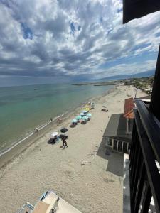 a beach with umbrellas and people on the sand at Nepheli in Paralia Katerinis