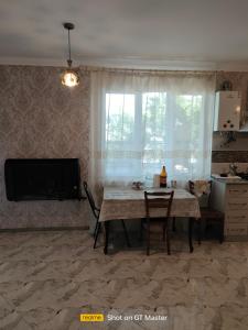 sala de estar con mesa y TV en Дом для одыха en Tiflis