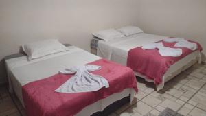 two beds in a room with red and white blankets at Pousada dos Girassóis in Conservatória