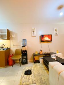 a living room with a couch and a tv on the wall at Feel Home -One bedroom with swimming pool in Kiambu