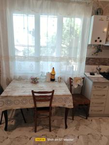 cocina con mesa, 2 sillas y ventana en Дом для одыха en Tiflis