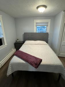 een slaapkamer met een bed met een deken erop bij Little Rhody in Pawtucket