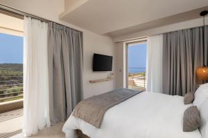 1 dormitorio con cama y ventana grande en Foneas Bay Villa, en Proástion