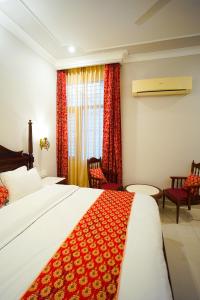 a bedroom with a large bed with a red blanket at Chitawa Haveli - A Luxury Heritage Hotel in Jaipur