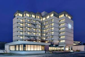 a large white building with many windows at night at NH Erlangen in Erlangen