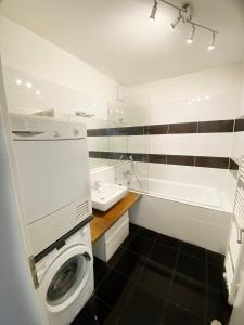 a bathroom with a washing machine and a sink at Apartment in the Heart of Ostrava in Moravská Ostrava