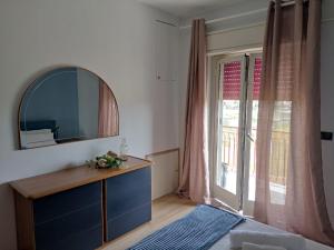 1 dormitorio con espejo, tocador y ventana en Stella Marina, en Giardini Naxos