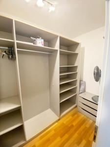 a walk in closet with white shelves and a toilet at Apartment in the Heart of Ostrava in Moravská Ostrava