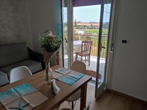 a living room with a table and a view of a balcony at Stella Marina in Giardini Naxos