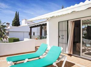 Un par de sillones verdes en un patio. en High Quality, Spacious, 4 Bedroom private Villa, en Santa Fe de los Boliches