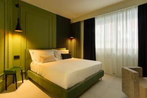 una camera con letto e parete verde di Welmy Napoli a Napoli