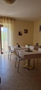 アルゲーロにあるB&B Casa Miaの白いテーブルと椅子、窓が備わる客室です。