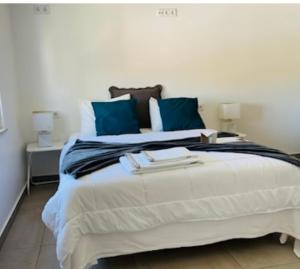 una camera da letto con un grande letto con cuscini blu di Kerart Lima ad Armação de Pêra
