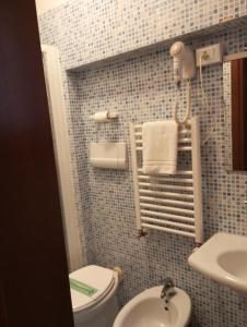 Baño pequeño con aseo y lavamanos en Hotel Henry, en Venecia