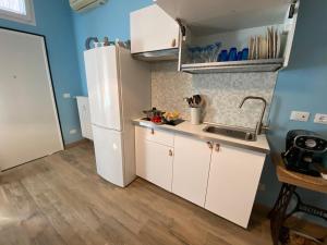 a small kitchen with white cabinets and a sink at Stalingrado Home - Fiera Bologna in Bologna