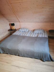 a bed in a room with a wooden wall at Stilove Wydmy in Sasino