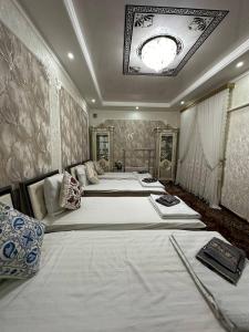 two beds in a large room with a ceiling at Khan hotel in Khiva
