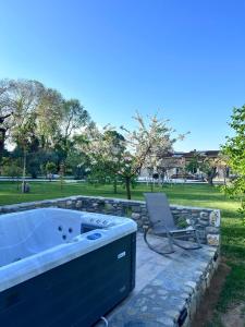 un bain à remous et une chaise dans un parc dans l'établissement Natura Bungalows, à Thasos