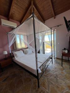 a bed with a canopy in a room at Alseides Villas in Chort&aacute;ta