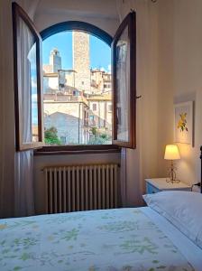 Schlafzimmer mit einem Bett und einem Fenster mit Aussicht in der Unterkunft Affittacamere Chiti Melania in San Gimignano
