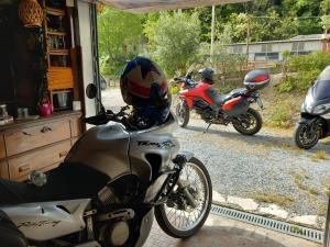dos motocicletas estacionadas fuera de una casa con un casco en La Badia, en Messina
