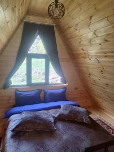 1 cama en una cabaña de madera con ventana en Gold Star en Kazbegi
