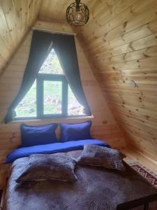 a bed in a log cabin with a window at Gold Star in Kazbegi