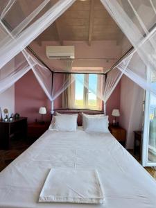 a large bed in a room with a large window at Alseides Villas in Chortáta