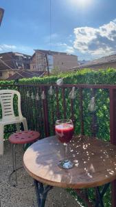 普里什蒂納的住宿－Prishtina Guests'，阳台上的木桌和一杯葡萄酒