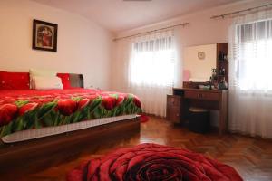 1 dormitorio con cama, escritorio y manta roja en Prishtina Guests', en Pristina