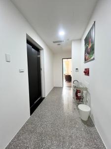 a hallway with white walls and a black door at Zhenai B&B in Daxi