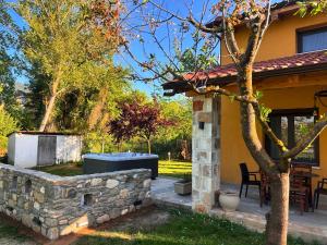 a house with a stone wall and a patio at Natura Bungalows in Limenas
