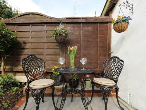 een patio met een tafel en 2 stoelen bij Larksworthy Cottage in North Tawton