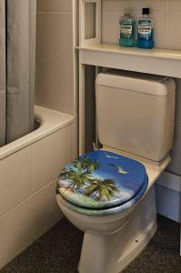 La salle de bains est pourvue de toilettes et d'un siège sur le thème des palmiers. dans l'établissement La Glorie/ The Glory/ La Gloria, à Pully