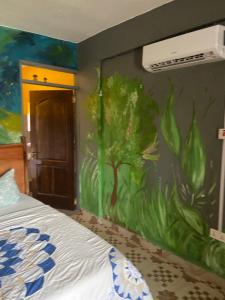 庫馬西的住宿－Bruks Guest House，卧室墙上有绘画作品