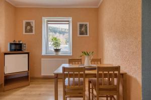 a dining room with a table and a tv at FAUNAPARK Lipová-lázně in Lipova Lazne