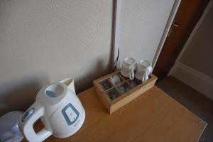 a table with a tea pot and a box on it at Mont Millais in Bridlington