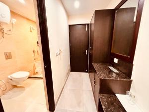 y baño con aseo, lavabo y ducha. en Intial Wood Resort en Rāmnagar