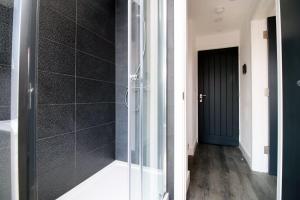 een badkamer met een douche en een glazen deur bij Boutique one bedroom apartment in Cardiff in Cardiff